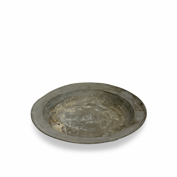 Antique pewter platter, round-oval shallow tray with worn, tarnished finish and raised rim.