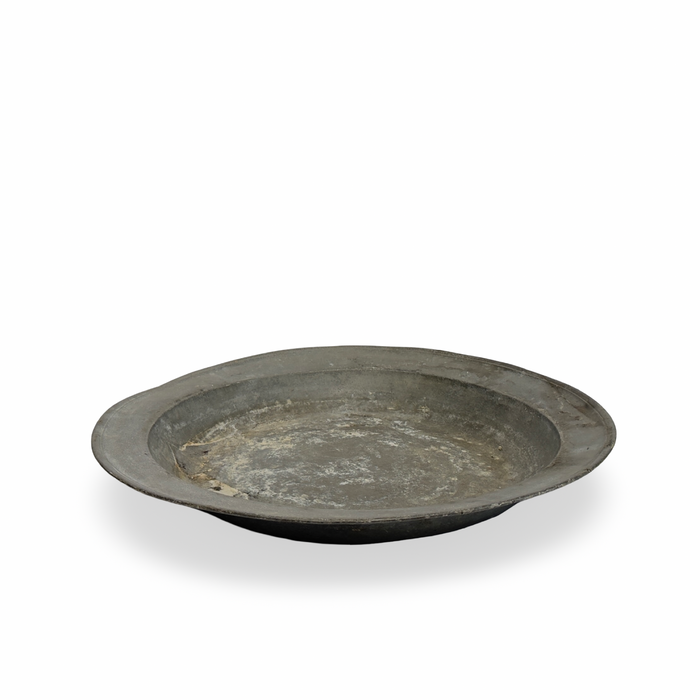 Antique pewter platter with tarnished surface and darkened rim, shown at slight angle.
