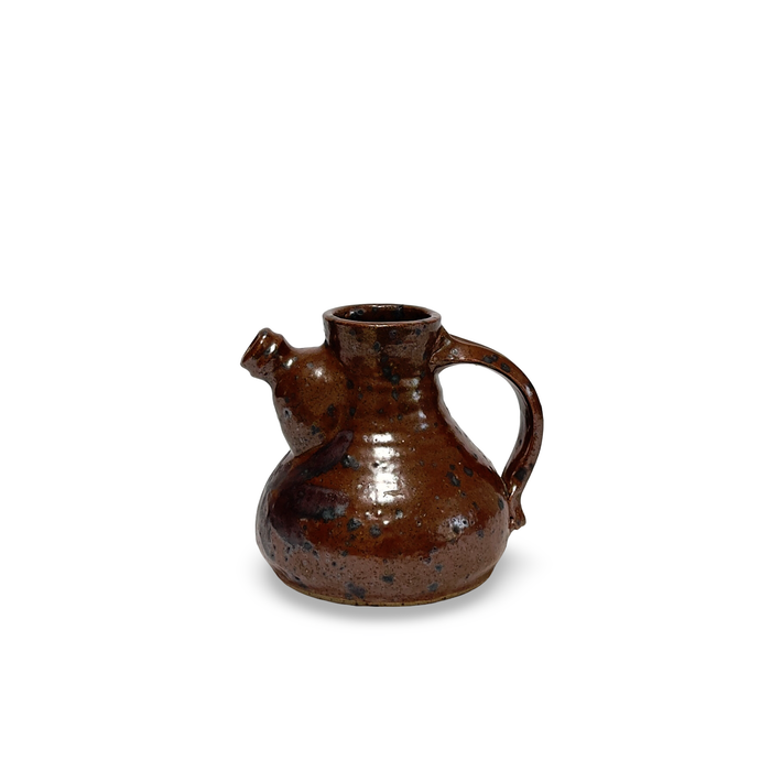 Brown glazed ceramic jug with loop handle and small side spout