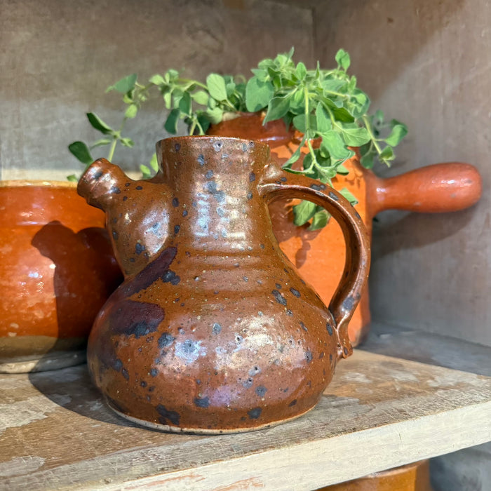 Brown glazed ceramic jug with side handle and spout, speckled finish