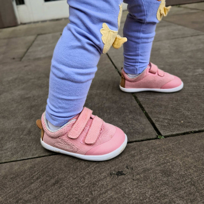 Barefoot toddler trainer in pink- close up on pavement