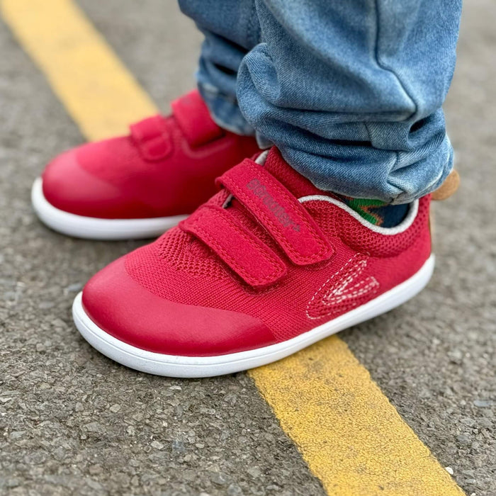 Toddler wearing red mesh trainers close up