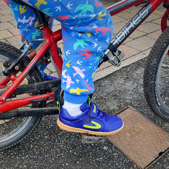 Boy wearing blue winter style trainers on bike