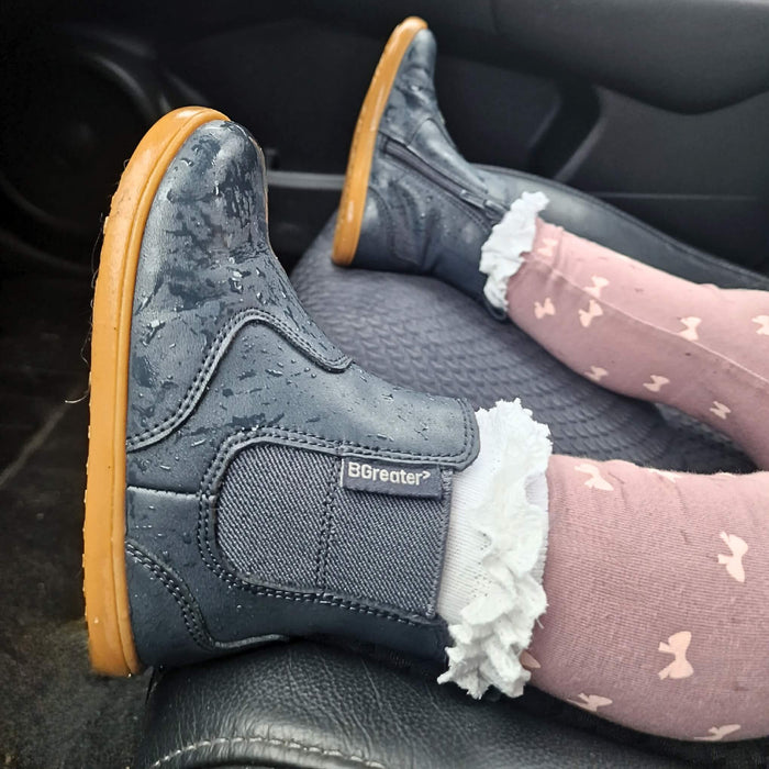 Toddler in car wearing wet navy barefoot style boots