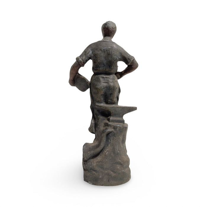 Antique cast metal statue of a standing woman with hands on hips, dark patina.