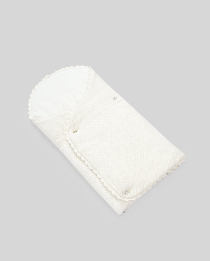 White folded baby nest on a gray background
