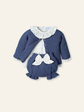 Children's blue sweater set with white ruffled collar and bow on a light beige background