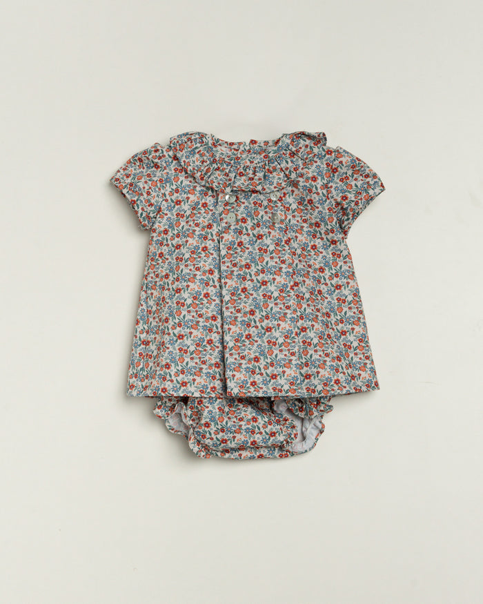 Floral baby outfit with top and bloomers on a light gray background
