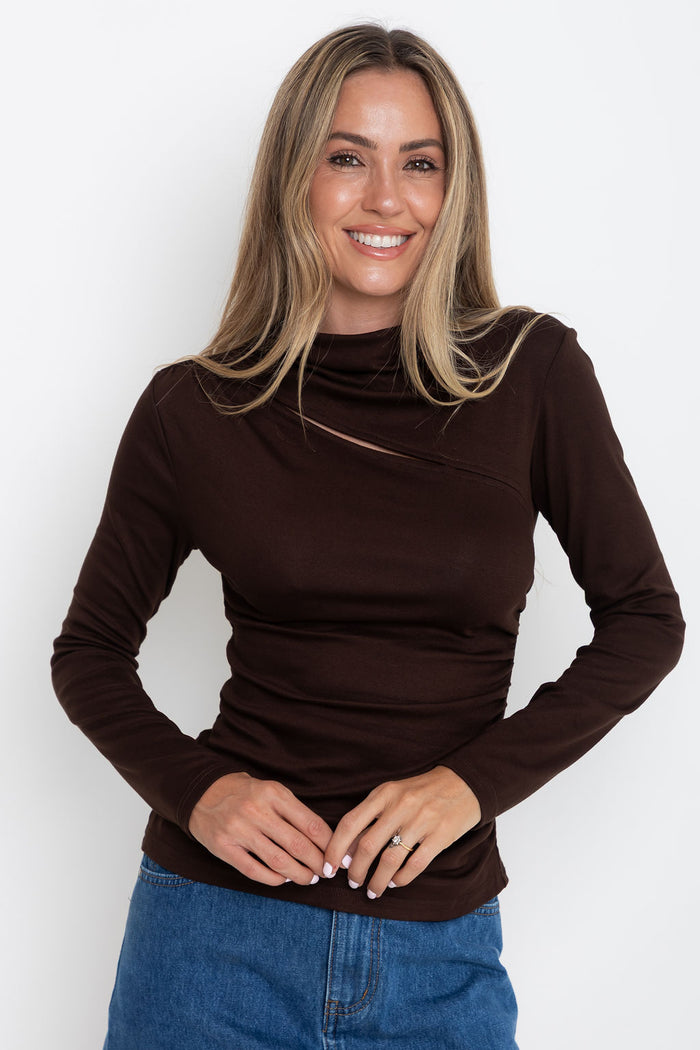 Carolyn long sleeve top in chocolate brown, fitted top with asymmetric cutout neckline, styled with a denim skirt