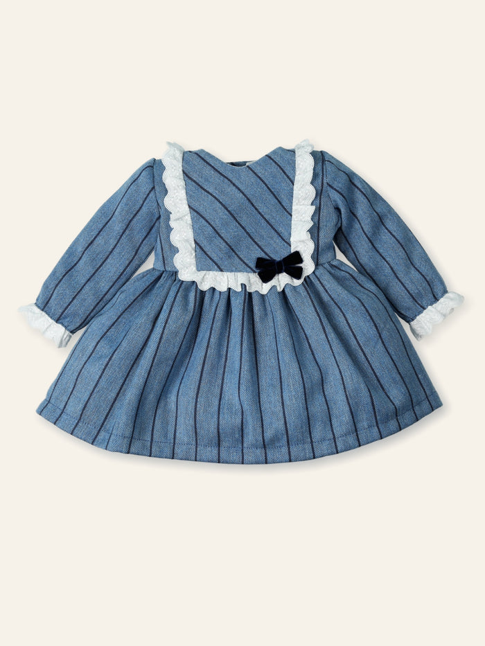 Blue dress with white ruffled collar and black bow on a beige background