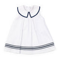 White dress with navy trim on a white background