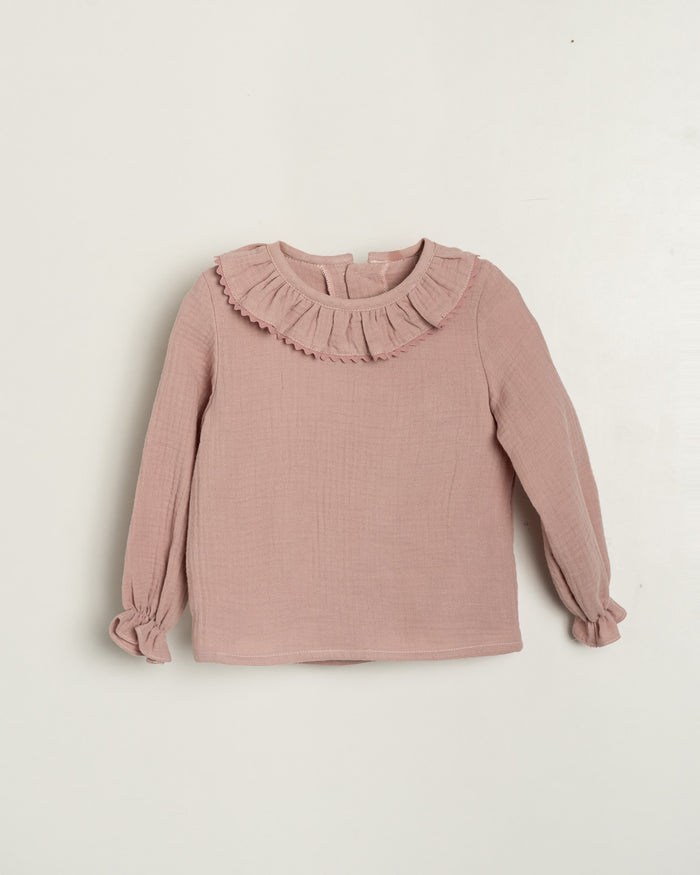 Pink blouse with ruffled collar on a light beige background