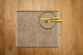 Gray square jacquard placemat with fringe border, set with plate and fork.
