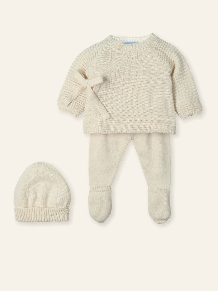 Knitted baby outfit with sweater, pants, and hat on a white background