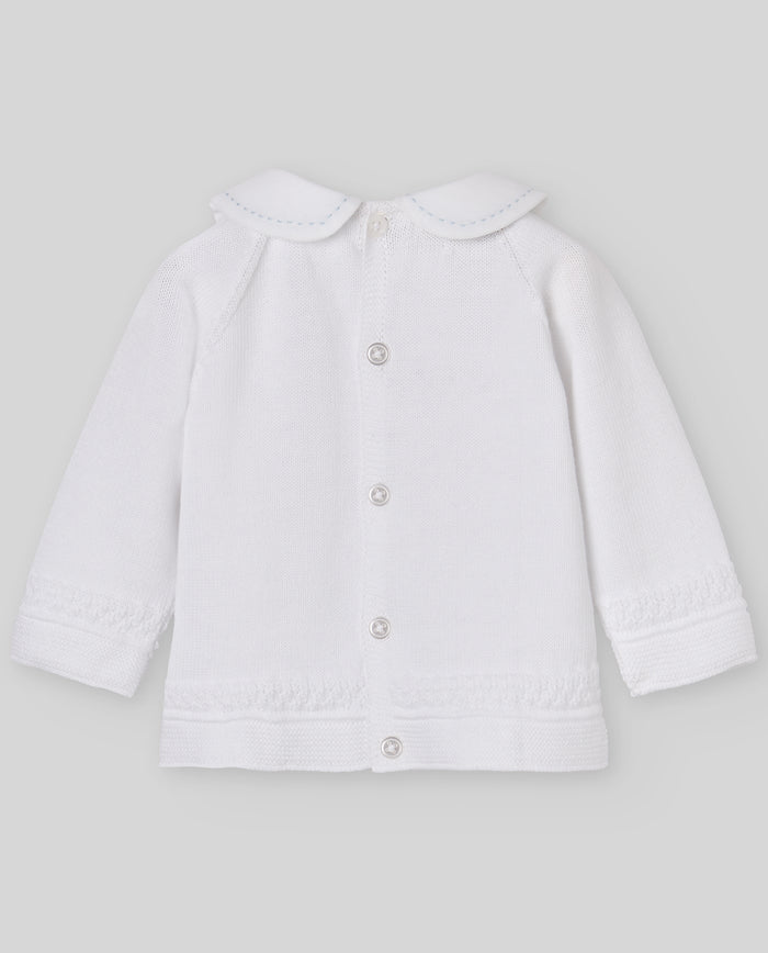 White baby jacket with buttons on a light gray background