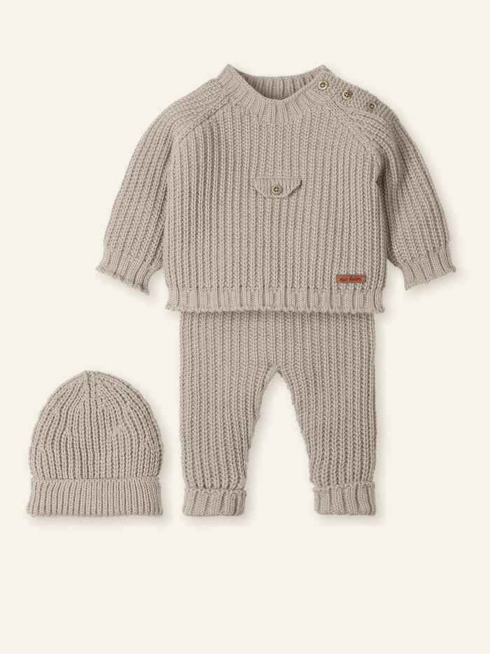 Knitted baby outfit with sweater, pants, and hat on a white background