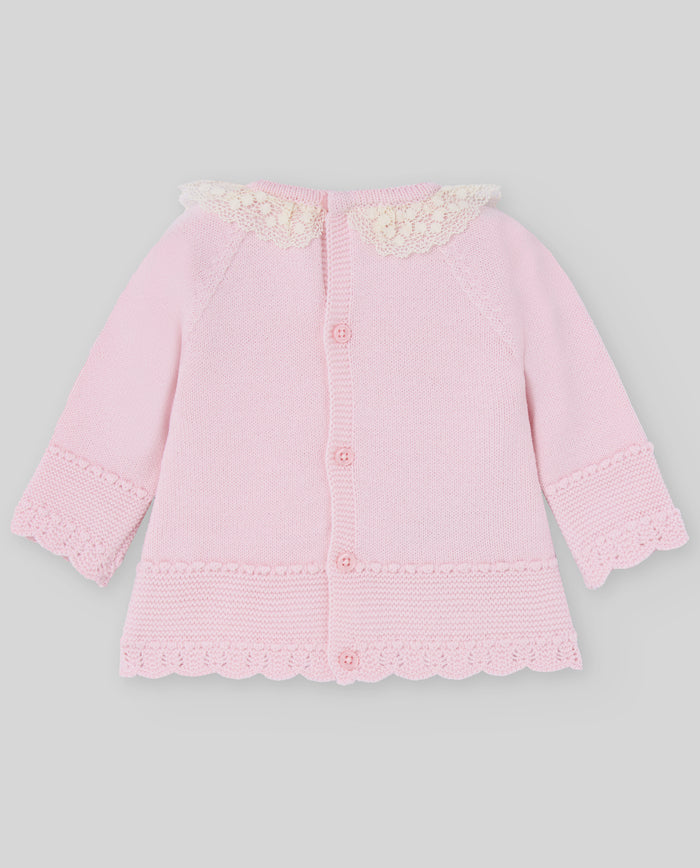 Pink baby cardigan with lace details on a gray background