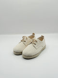 Pair of beige shoes on a white background