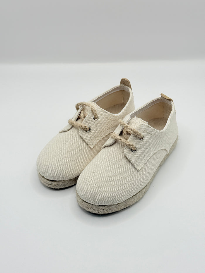 Pair of beige baby shoes on a light gray background