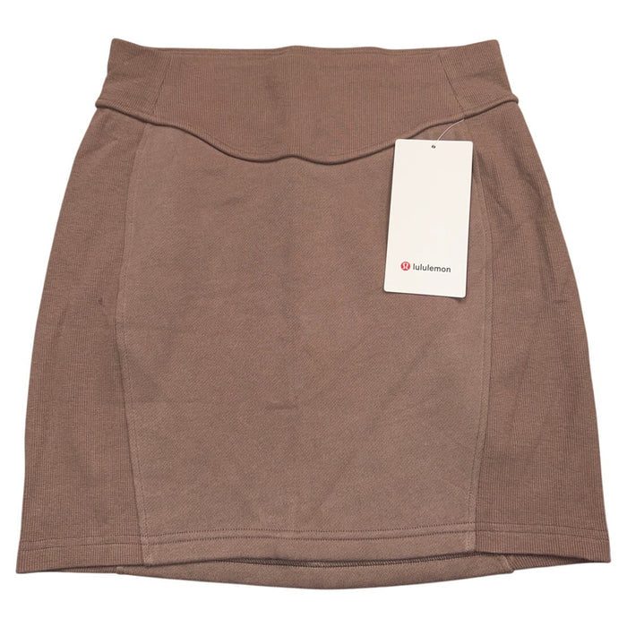 Lululemon Scuba high-rise mini skirt in brown, women's size large, shown on a model with a fitted style and soft fabric.