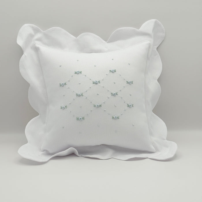 White decorative pillow with ruffled edges on a light gray background