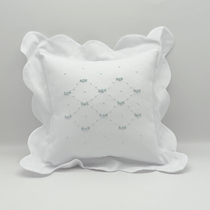 Decorative pillow with scalloped edge on a light gray background