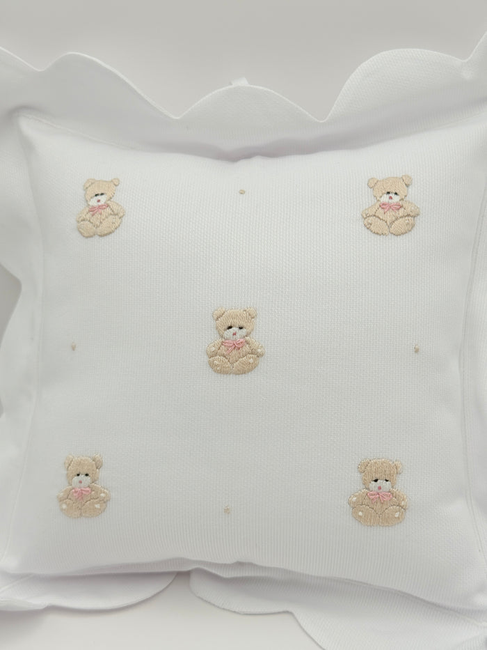 White fabric with embroidered teddy bear designs on a white background