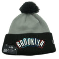 New Era Brooklyn Nets knit beanie with embroidered logo and removable pom, soft knit fabric, stylish winter hat.