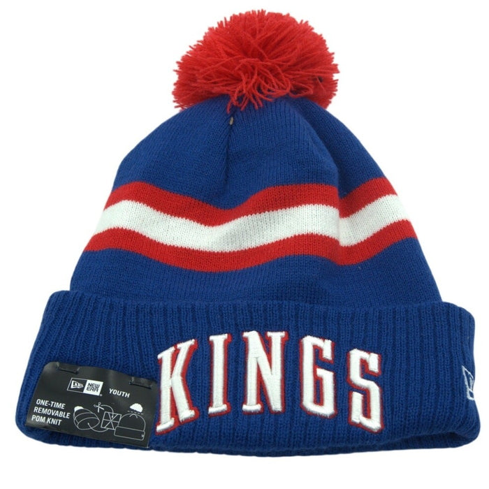 Youth NBA Sacramento Kings pom beanie hat in blue and red, knit with team logo and pom pom on top.
