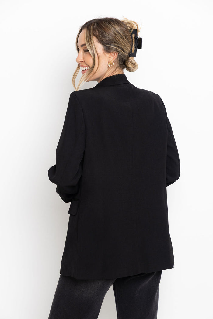 Woman wearing a black blazer against a white background