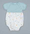 Baby romper with light mint top and white bottom with animal pattern on a white background.