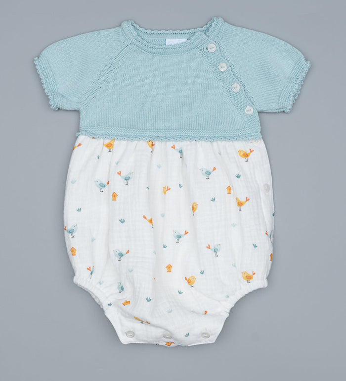Baby romper with light mint top and white bottom with animal pattern on a white background.