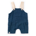 Blue denim overalls with beige straps on a white background