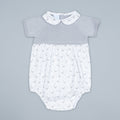 Baby romper with duck pattern on a gray background