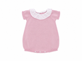 Pink knitted baby dress with white collar on a white background