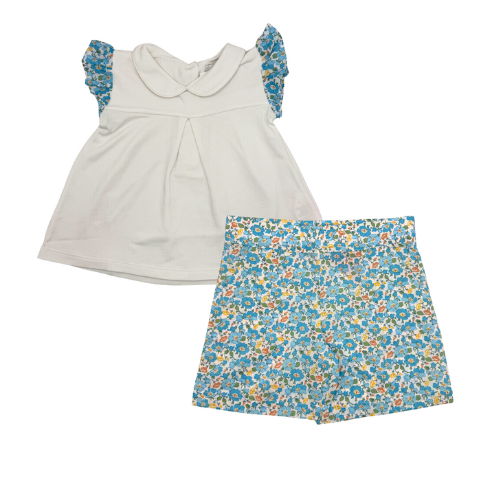 White top with floral sleeves and a blue floral skirt on a white background