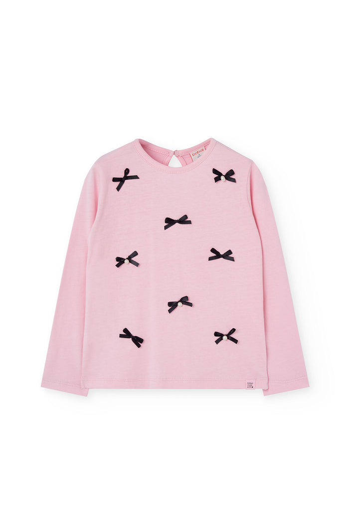 Pink long-sleeve top with black bow details on a white background