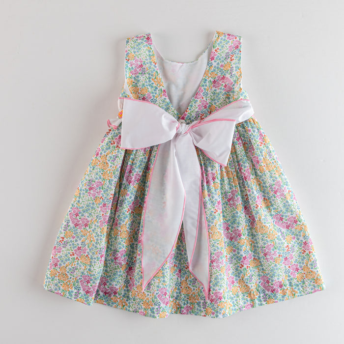 Floral dress with a large bow on a light gray background