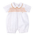 White baby romper with orange lattice pattern on a white background