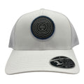 TravisMathew FlexFit Tech "The Patch" hat, style #1M8296, in a close-up showing the hat's fabric and embroidered patch detail.