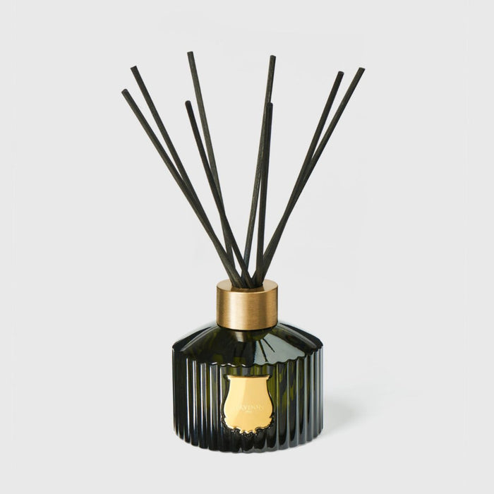 Black ribbed glass reed diffuser with gold cap and five reeds