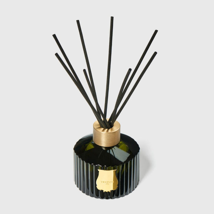 Black ribbed glass reed diffuser with gold top and upright reeds