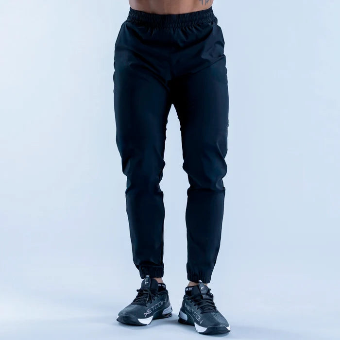 Dark training jogger pants front view with elastic waistband and ankle cuffs