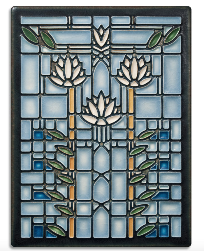 A handmade ceramic tile with a stylized waterlily design in blue and green colors, inspired by Frank Lloyd Wright's drawing.