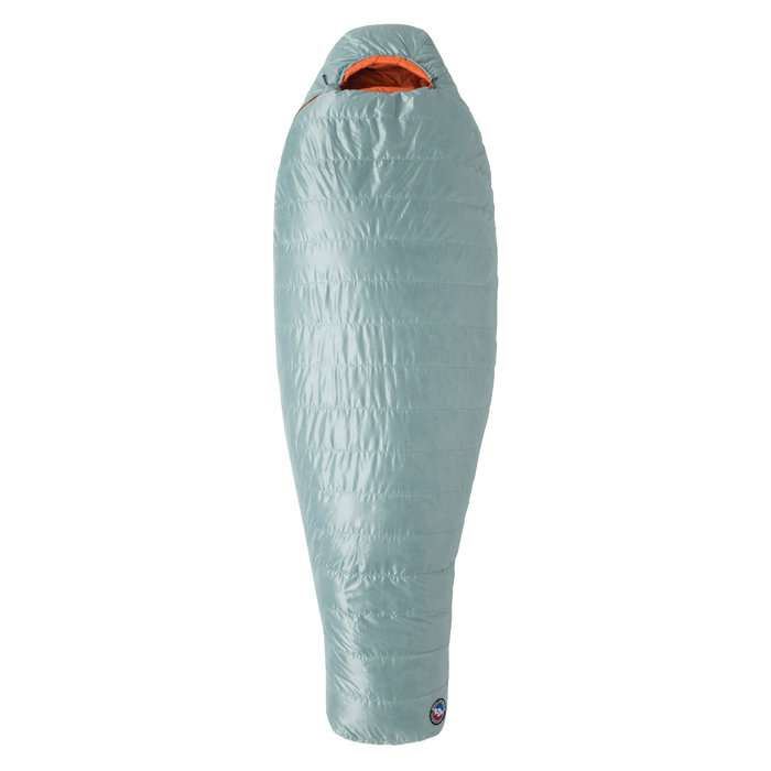 The Big Agnes Returns Women's Greystone 30° mummy sleeping bag in light blue features an orange interior, tapered footbox, and hooded top for head coverage. It is displayed upright against a plain white background.
