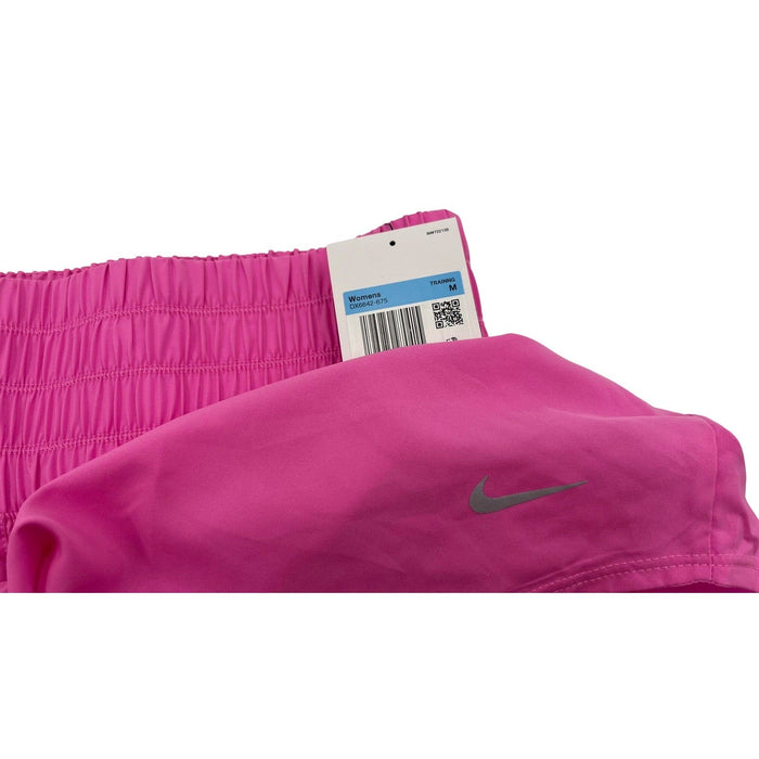 Nike women's pink high-waisted Dri-FIT training shorts, medium size, shown flat with elastic waistband and athletic fit