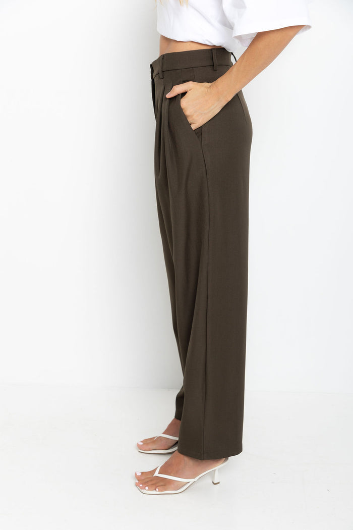 Xavier pants in dark olive brown – high-waisted, wide-leg trousers with pleated front, worn with a white cropped tee and thong sandals